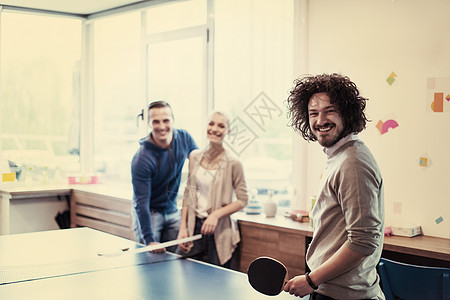 群轻的创业商人现代创意办公室打乒乓球图片