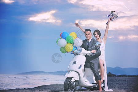 新娘新郎的婚礼Sce刚刚海滩上结婚,骑着白色的滑板车,玩得开心背景图片