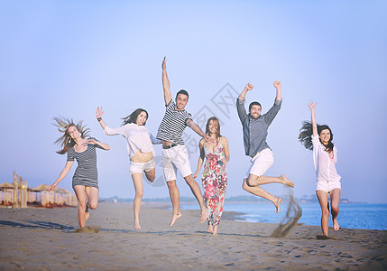 快乐的轻人体乐趣的跑步跳跃海滩美丽的沙滩背景图片