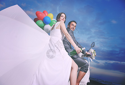 婚礼气球新娘新郎的婚礼Sce刚刚海滩上结婚,骑着白色的滑板车,玩得开心背景