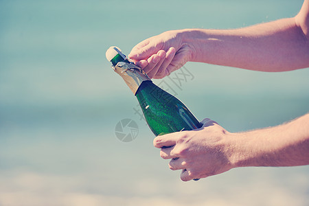 男子手打开瓶香槟酒葡萄酒饮料户外派庆祝活动图片