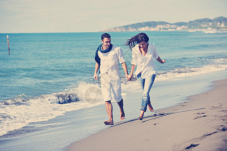 穿着白色衣服的快乐轻夫妇美丽的海滩度假时浪漫的娱乐活动乐趣图片