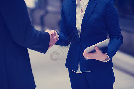 与企业的伙伴关系理念,男女握手,并现代办公室内部达成协议图片