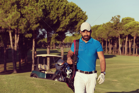 英俊的中东高尔夫球手背着包,走高尔夫球场的下个洞高尔夫球手步行携带高尔夫球袋图片