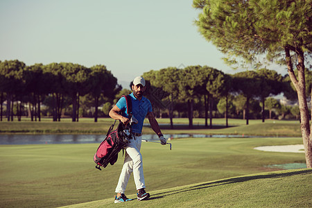 英俊的中东高尔夫球手背着包,走高尔夫球场的下个洞高尔夫球手走路提包图片