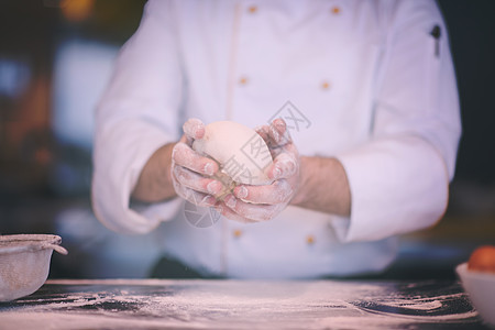 厨师手准备,桌子上撒粉特写厨师手准备比萨饼的图片