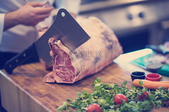 厨师餐厅厨房用斧头木板上切大块牛肉厨师切大块牛肉图片