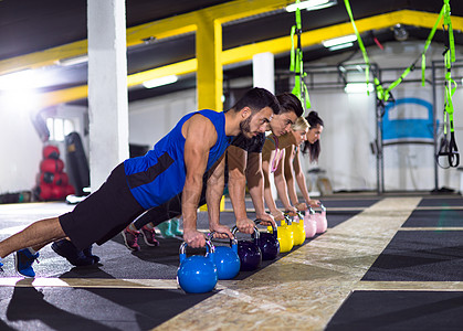 群轻的健康运动员交叉健身健身房用水壶俯卧撑轻运动员用水壶俯卧撑图片