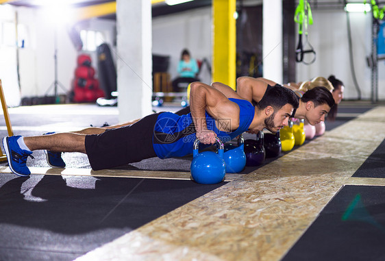 群轻的健康运动员交叉健身健身房用水壶俯卧撑轻运动员用水壶俯卧撑图片