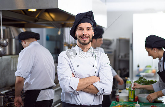 轻厨师站餐厅商业厨房的肖像轻厨师的肖像图片