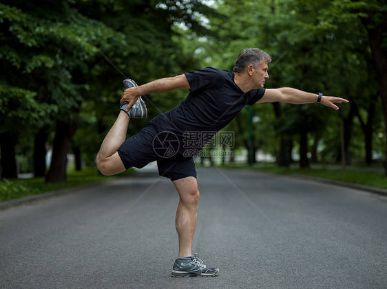 男跑步者早上训练前热身伸展健康的男跑步者早上训练前城市公园热身伸展图片