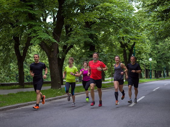 跑步队参加上午的训练群健康的人城市公园慢跑,跑步队参加晨训图片