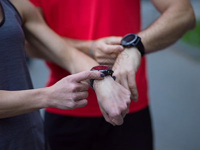 运动夫妇用智能手表轻的运动夫妇用智能手表启动他们的计时器,然后慢跑图片