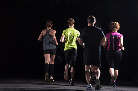 跑步男跑步队参加夜间训练群健康的人城市公园慢跑,跑步队夜间训练背景