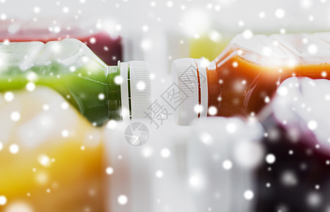 健康的饮食,饮料,饮食排塑料瓶与同的水果蔬菜汁白色雪上同水果蔬菜汁的瓶子图片