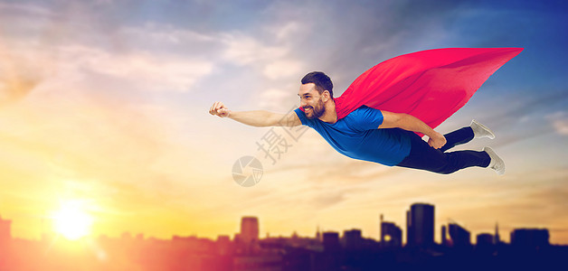 自由,权力,运动人的快乐的人红色超级英雄斗篷空中飞行的城市阳光背景穿着红色超级英雄斗篷的快乐男人飞过城市图片