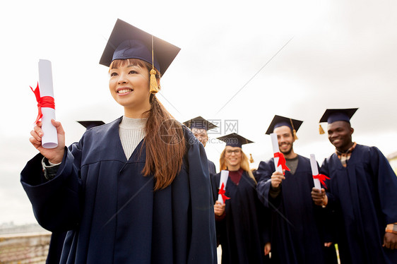 教育,毕业人的群快乐的国际学生迫击炮板学士学位礼服与文凭文凭的迫击炮板上快乐的学生图片