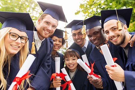 教育,毕业人的群快乐的国际学生迫击炮板学士学位礼服与文凭文凭的迫击炮板上快乐的学生图片