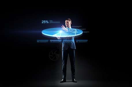商业,人未来的技术商人适合与虚拟饼图投影黑色背景穿着西装的商人用虚拟饼图工作图片