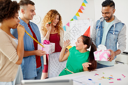 公司,庆祝人的快乐队与礼物问候女同事办公室生日聚会队办公室生日聚会上问候同事图片
