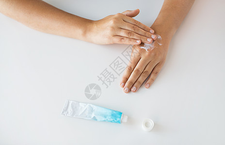 医学,医疗保健人的密切妇女的手应用奶油治疗药膏用奶油治疗药膏双手图片