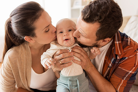 家庭父母人的快乐的母亲父亲家里亲吻小婴儿快乐的母亲父亲家里亲吻婴儿图片
