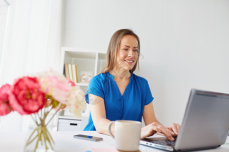 商业,人技术的快乐的微笑中妇女与笔记本电脑工作家里办公室快乐的女人,家里办公室工作的笔记本电脑图片