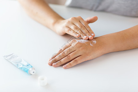 医学,医疗保健人的密切妇女的手应用奶油治疗药膏用奶油治疗药膏双手图片