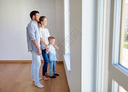 家庭,人房地产的快乐的母亲,父亲小儿子透过窗户看着新的家公寓幸福的家庭与孩子新的家公寓图片