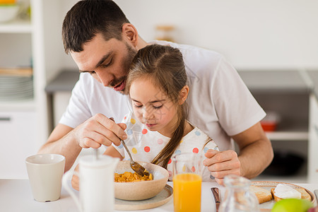 家庭人们的快乐的父亲女儿家里吃早餐片幸福的家庭家里吃薄片早餐图片