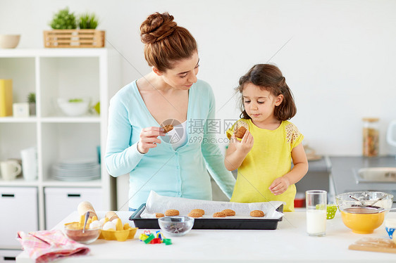 家庭,烘焙,烹饪人们的快乐的母亲小女儿家里厨房吃饼干快乐的母亲女儿家吃饼干图片