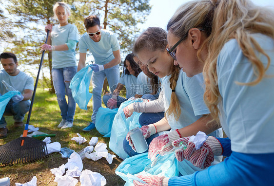 志愿服务慈善人生态理念公园内群带垃圾袋耙清理区域的快乐志愿者志愿者用垃圾袋清洁公园区域图片