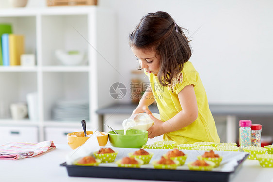 家庭,烹饪,烘焙人们的小女孩为松饼纸杯蛋糕糊,并家庭厨房添加牛奶小女孩家烤松饼图片
