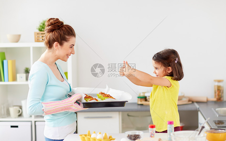 ‘~家庭,烘焙,烹饪人的母亲着盘松饼小女儿家里厨房竖大拇指母女俩家烤松饼  ~’ 的图片