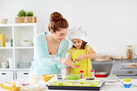 家庭,烹饪,烘焙人们的快乐的母亲与小女儿添加巧克力纸杯蛋糕衬里制作松饼家厨房快乐的母亲女儿家烤纸杯蛋糕图片