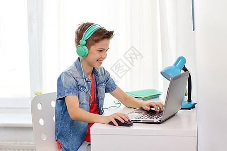 技术,游戏人的男孩耳机玩电子游戏笔记本电脑家里戴耳机的男孩笔记本电脑上玩电子游戏图片