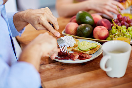 食物人的人的手与叉子吃培根桌子上叉子的人满食物的桌子上吃培根图片