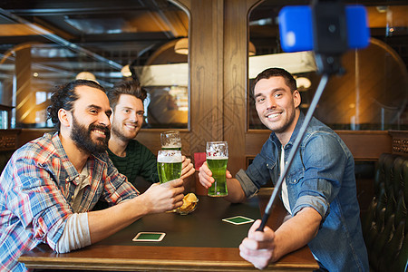 人们,休闲,帕特里克达技术快乐的男朋友喝啤酒拍照智能手机自拍棒酒吧酒吧朋友们酒吧自拍喝啤酒图片