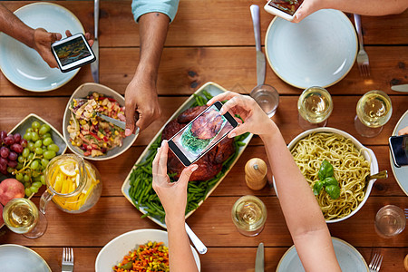感恩节,饮食,人技术人们用智能手机拍摄食物桌子上人们用智能手机拍摄食物图片