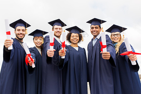 教育,毕业人的群快乐的国际学生迫击炮板学士学位礼服与文凭文凭的迫击炮板上快乐的学生图片