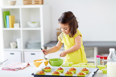 家庭,烹饪,烘焙人的小女孩糊松饼纸杯蛋糕家里厨房小女孩家烤松饼图片
