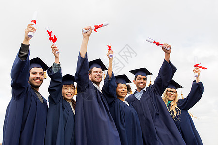 教育毕业人的群快乐的国际学生穿着灰浆板学士服,毕业证书庆祝成功文凭的迫击炮板上快乐的学生人多民族高清图片素材