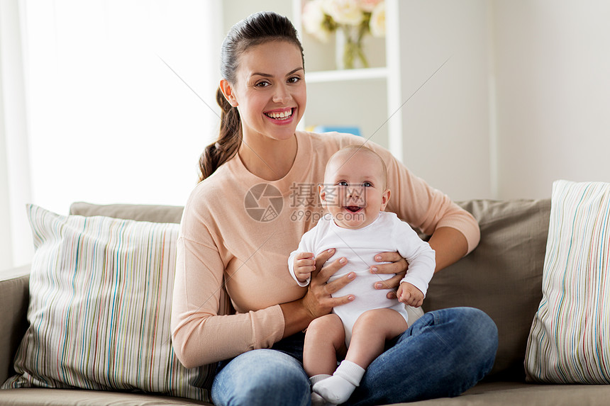 家庭母亲人的快乐的母亲小男孩坐家里的沙发上快乐的母亲小男孩家里图片