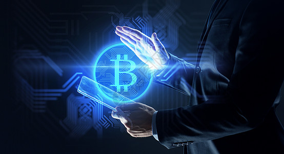 商业,加密货币未来的技术商人与透明平板电脑虚拟比特币符号全息图黑色背景拥平板电脑比特币全息图的商人图片