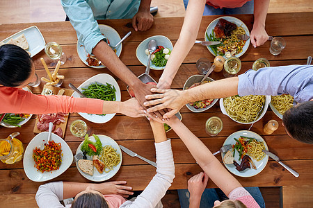 饮食休闲的群人吃晚饭,手牵着手桌子上吃东西人们用食物桌子上牵手图片