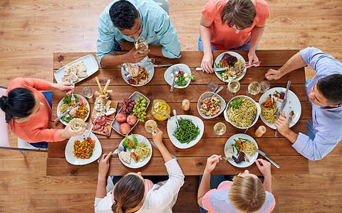 饮食休闲群人餐桌上吃晚饭群人桌子上吃食物高清图片