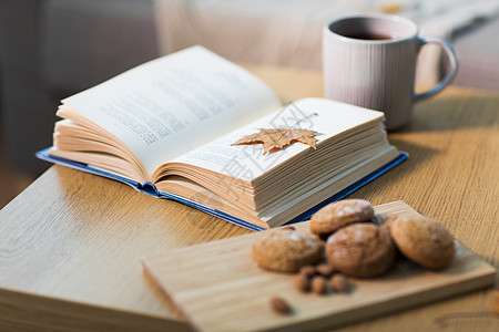 潮湿舒适的家庭书与秋叶,杯茶燕麦饼干木桌上桌上秋叶饼干茶图片