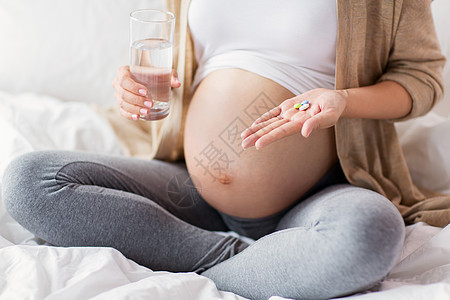 怀孕,人保健密切孕妇坐家里的床上,用药丸杯水把孕妇关床上吃药图片