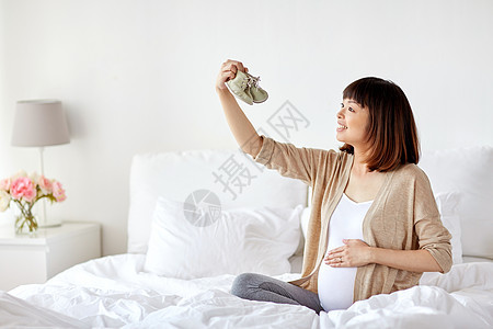 怀孕,人产妇的快乐的怀孕亚洲妇女与婴儿坐床上的卧室快乐的孕妇波蒂丝家里睡觉图片