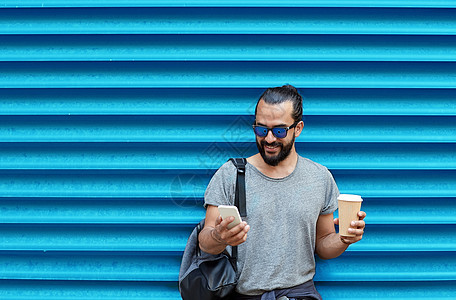 饮料,技术人的近距离的人与咖啡杯智能手机街道上的肋骨蓝墙背景男人带着咖啡杯智能手机蓝色的墙上图片